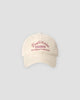 Beige washed dad cap with pink script embroidery, front view