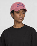 Model wearing the pink dad cap with navy embroidery, three-quarter view