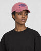Model wearing the pink dad cap with navy embroidery, three-quarter view