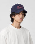 Model wearing the navy script embroidered dad cap, three-quarter view