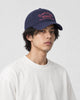 Model wearing the navy script embroidered dad cap, three-quarter view