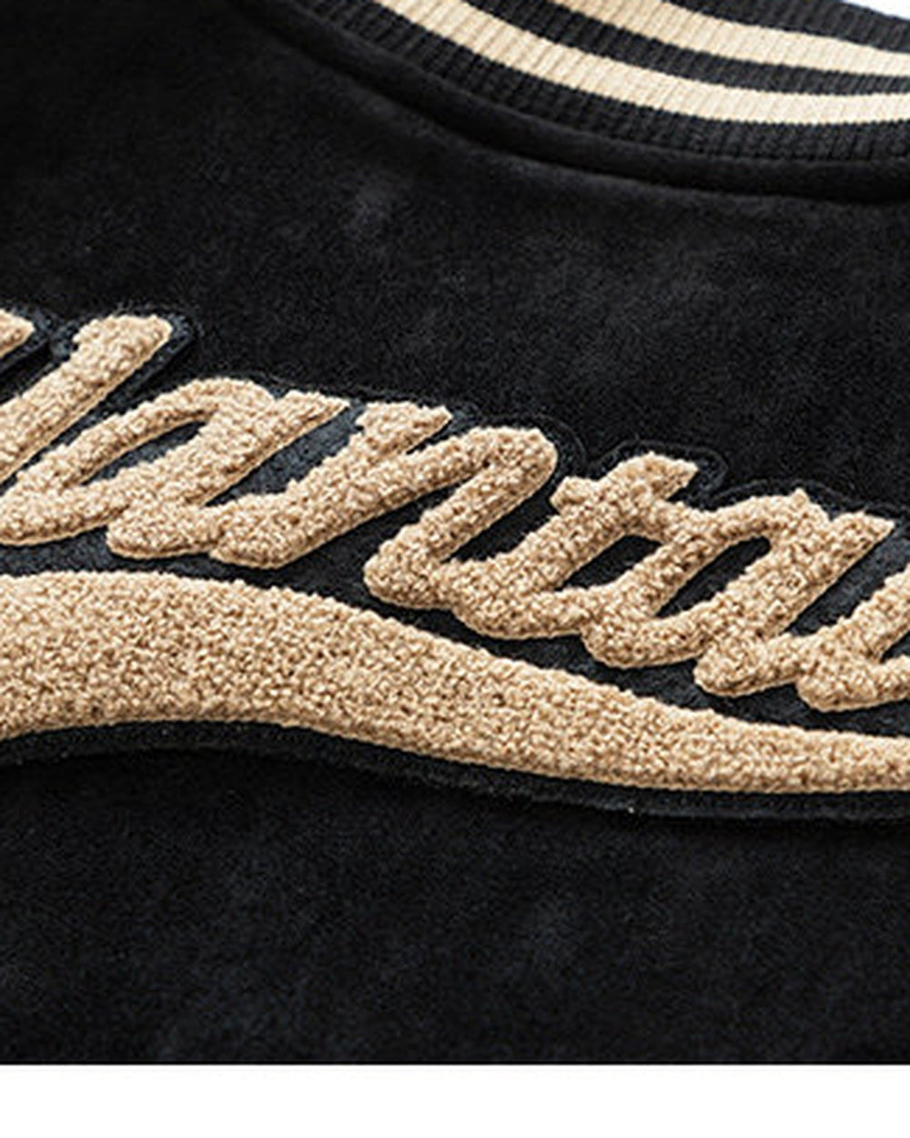 Close-up of the looped towel embroidery on the black faux suede
