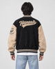Model wearing the black script letter varsity jacket, back view