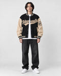 Model wearing the black script letter varsity jacket, front view