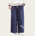 Person wearing navy blue pants with white embroidery