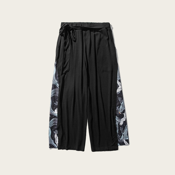 Black pants with floral side panels on a white background