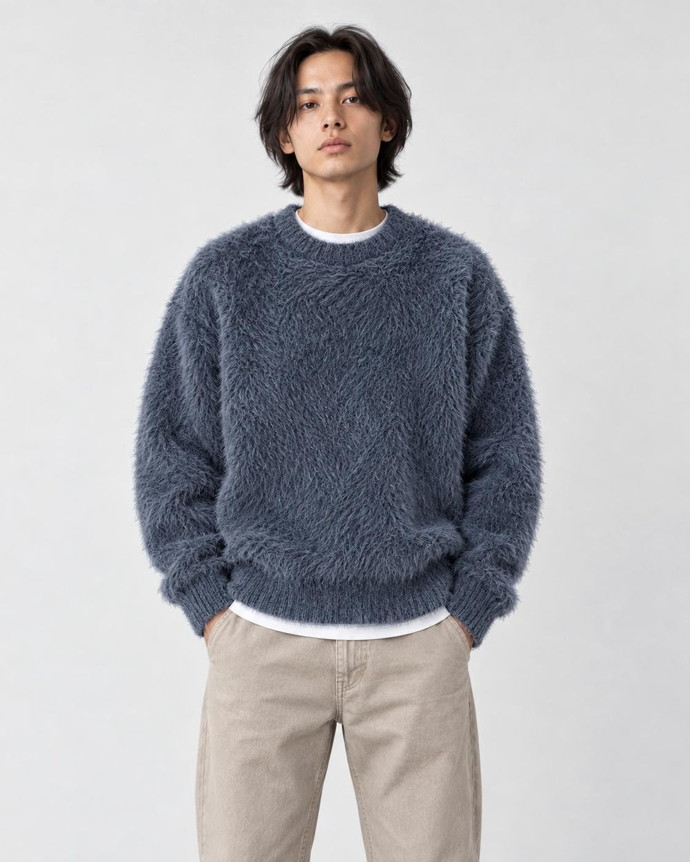 Model wearing the blue-gray shaggy knit sweater with dark jeans, front view