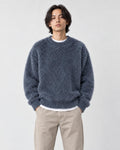 Model wearing the blue-gray shaggy knit sweater with dark jeans, front view