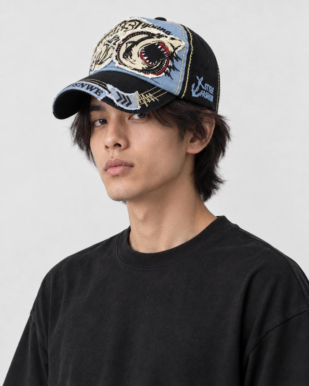 Model wearing the denim blue shark patch cap, three-quarter view