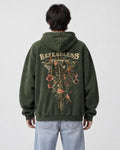 Model wearing the green skeleton flower hoodie with light-wash jeans, back view