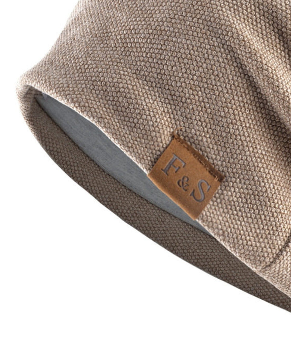 Close-up of the tan leather-look F&S patch and the textured knit on the khaki beanie