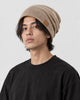 Model wearing the khaki slouch beanie with a black tee, three-quarter view