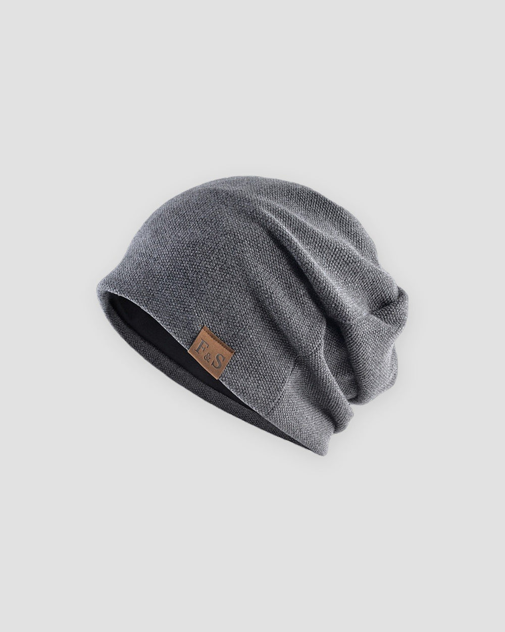 Dark gray slouchy textured knit beanie with a brown PU leather patch