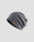 Dark gray slouchy textured knit beanie with a brown PU leather patch