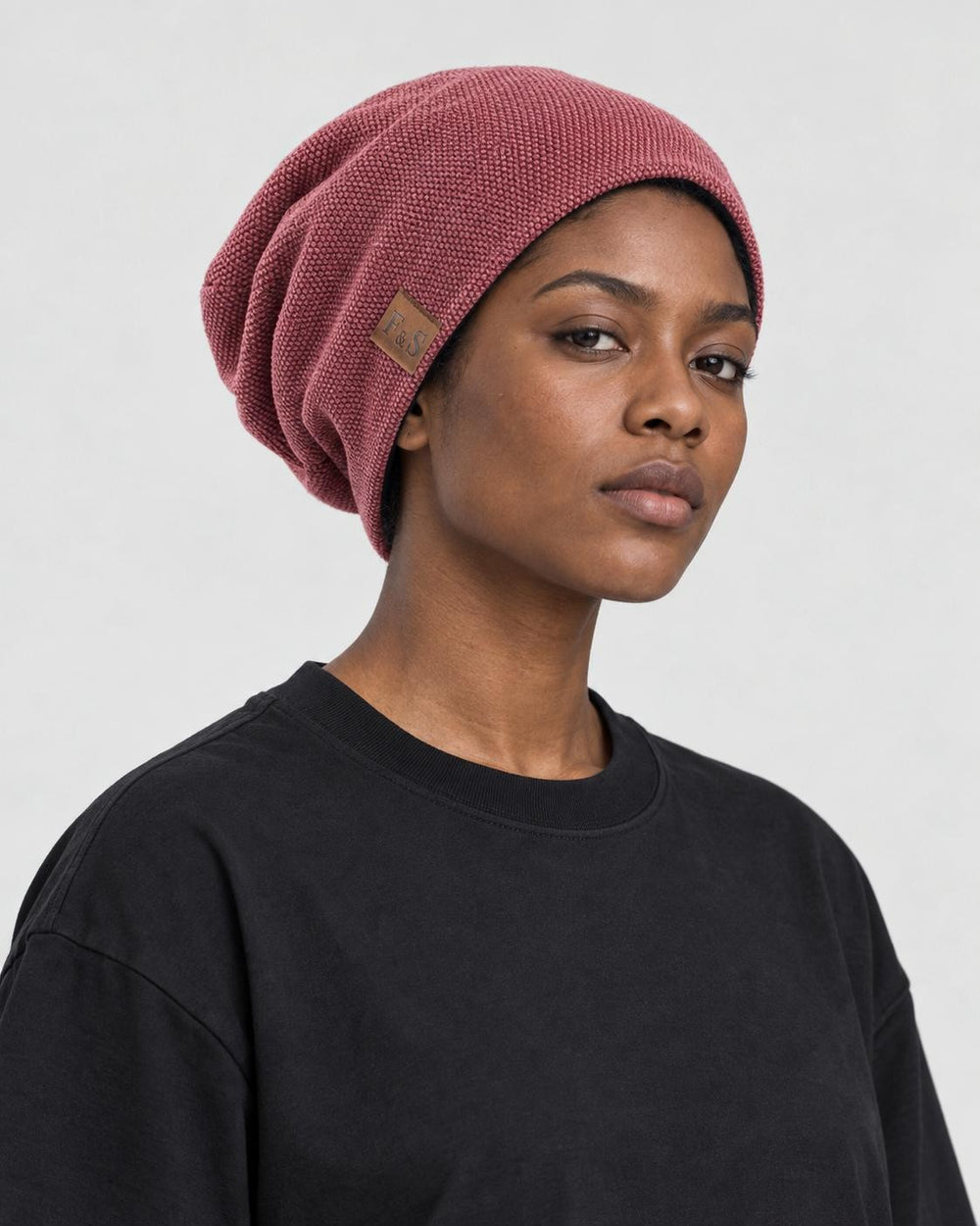 Model wearing the red slouchy beanie, three-quarter view