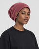 Model wearing the red slouchy beanie, three-quarter view