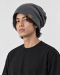 Model wearing the dark gray slouchy beanie, three-quarter view