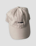 Beige baseball cap with a small black whale embroidered at the front center
