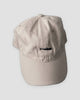 Beige baseball cap with a small black whale embroidered at the front center