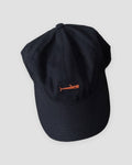 Navy baseball cap with a small orange whale embroidered at the front center