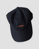 Navy baseball cap with a small orange whale embroidered at the front center