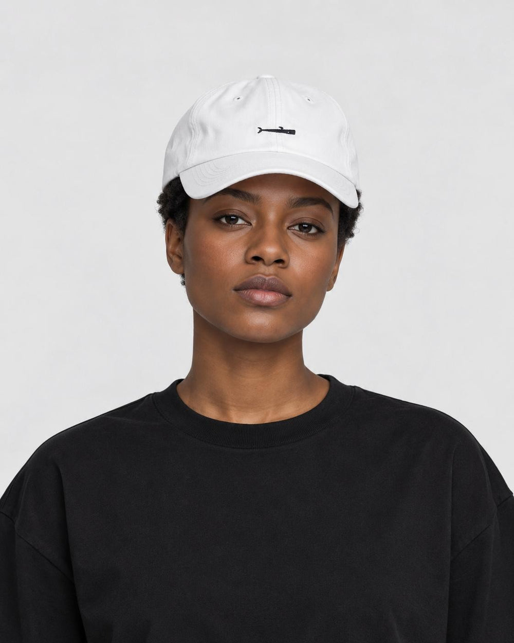 Model wearing the white whale cap with a black tee, side view