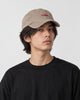 Model wearing the khaki whale cap with a black tee, three-quarter view