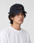 Model wearing the navy whale cap with a white tee, three-quarter view