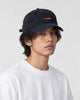 Model wearing the navy whale cap with a white tee, three-quarter view