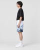 Model wearing the snowy mountain print shorts with a black T-shirt, side view