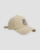 Cream baseball cap with a black embroidered seated cat and katakana, three-quarter view