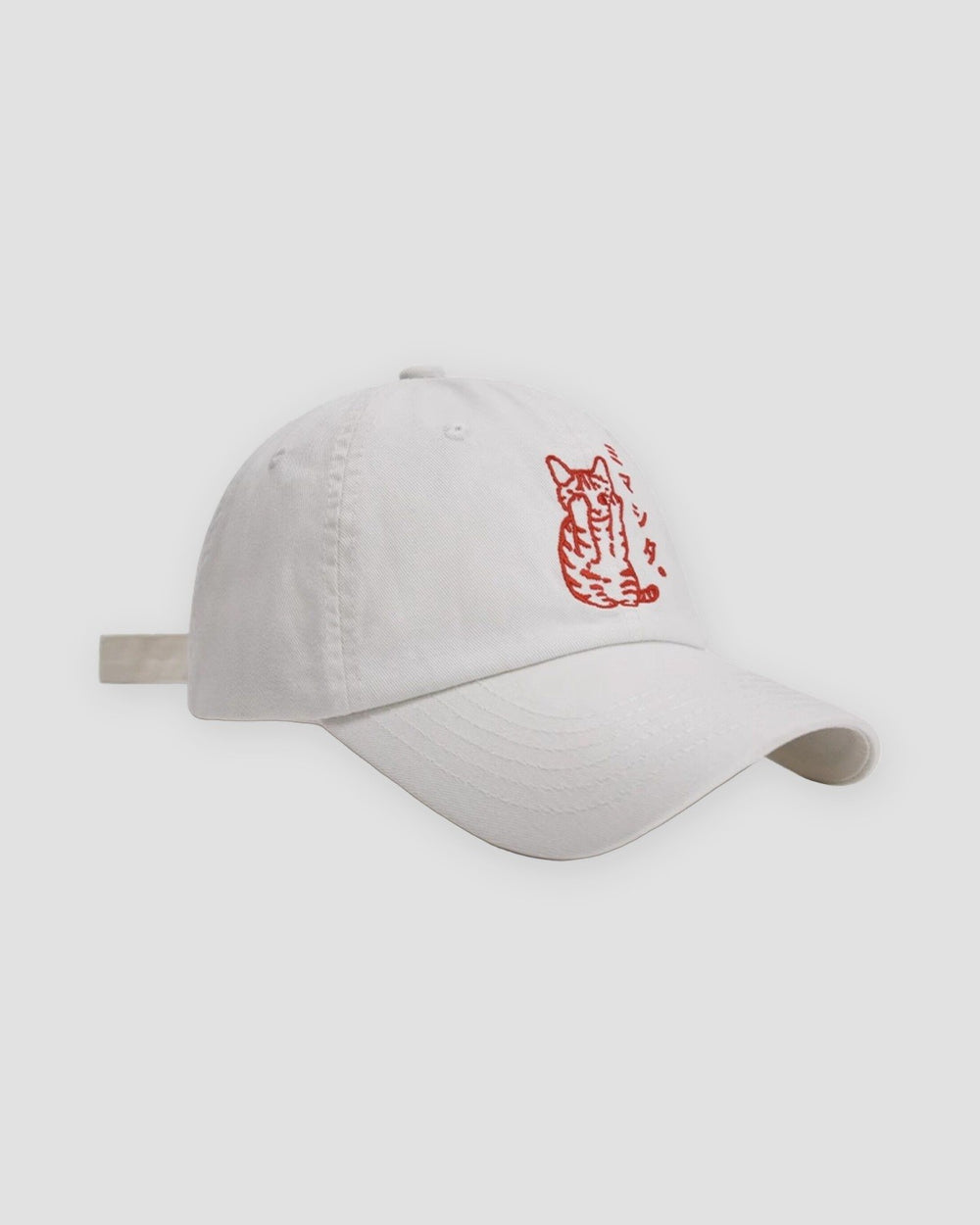White baseball cap with a red embroidered seated cat and katakana, three-quarter view
