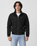 Model wearing the black field jacket zipped over a white tee and light-wash jeans, front view