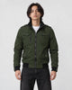 Model wearing the army green field jacket zipped over a white tee and black jeans, front view