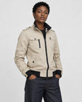 Model wearing the beige field jacket zipped over a black tee and dark jeans, three-quarter view