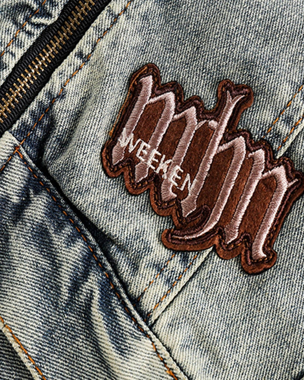 Close-up of the raised maroon script patch on the front