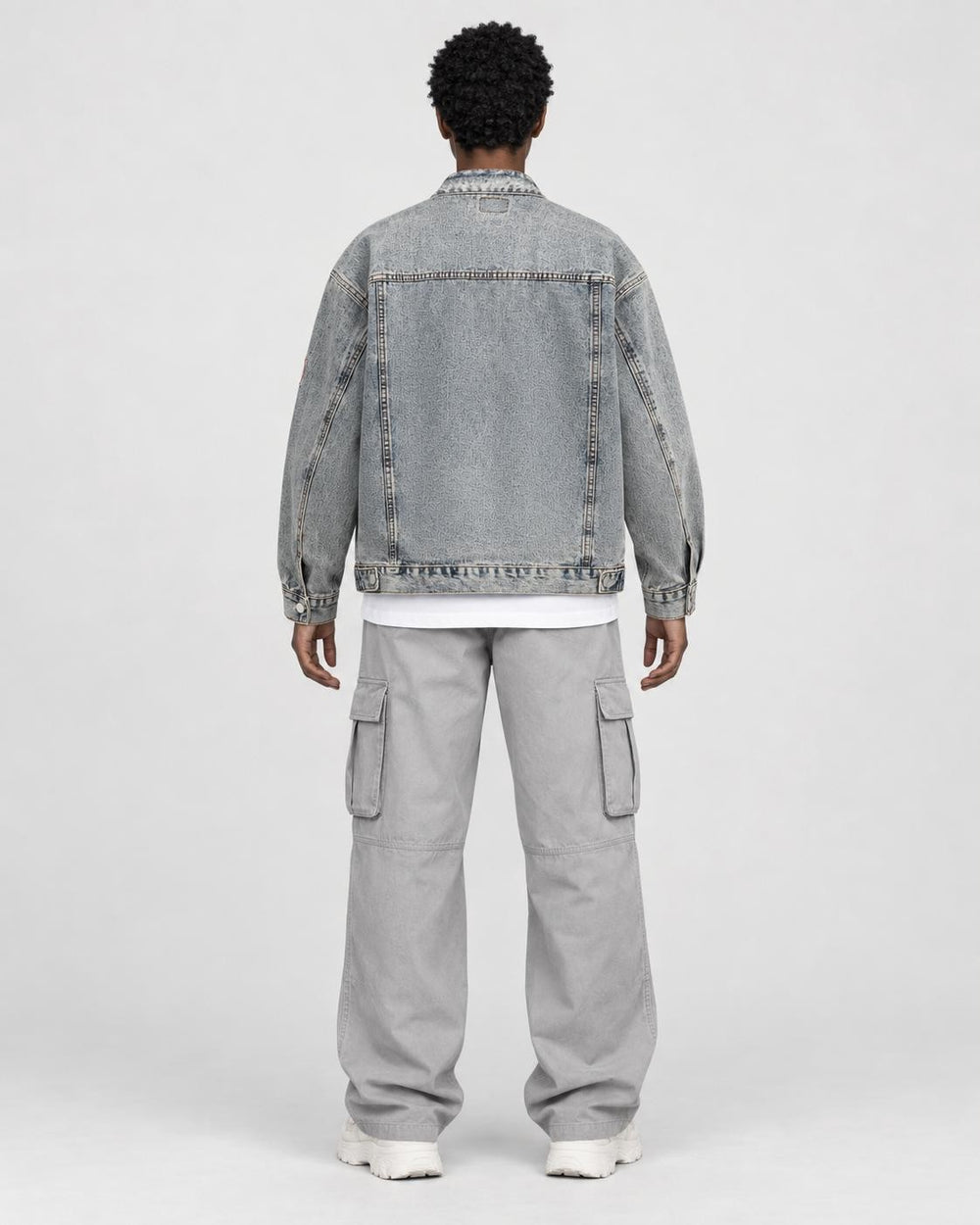 Model wearing the faded patch denim jacket, back view