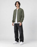 Model wearing the army green striped bomber jacket, three-quarter view