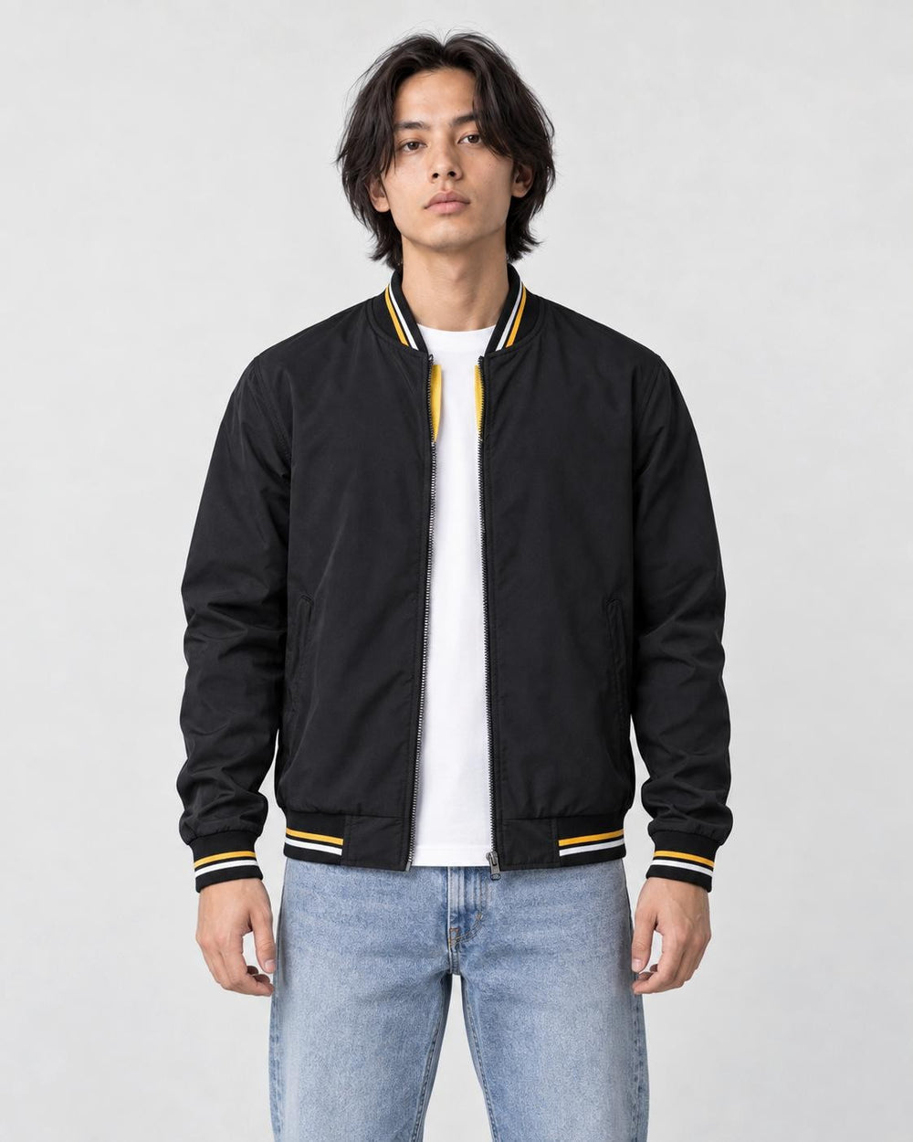 Model wearing the black striped bomber jacket over a white tee, front view