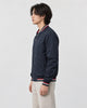 Model wearing the navy striped bomber jacket, side view