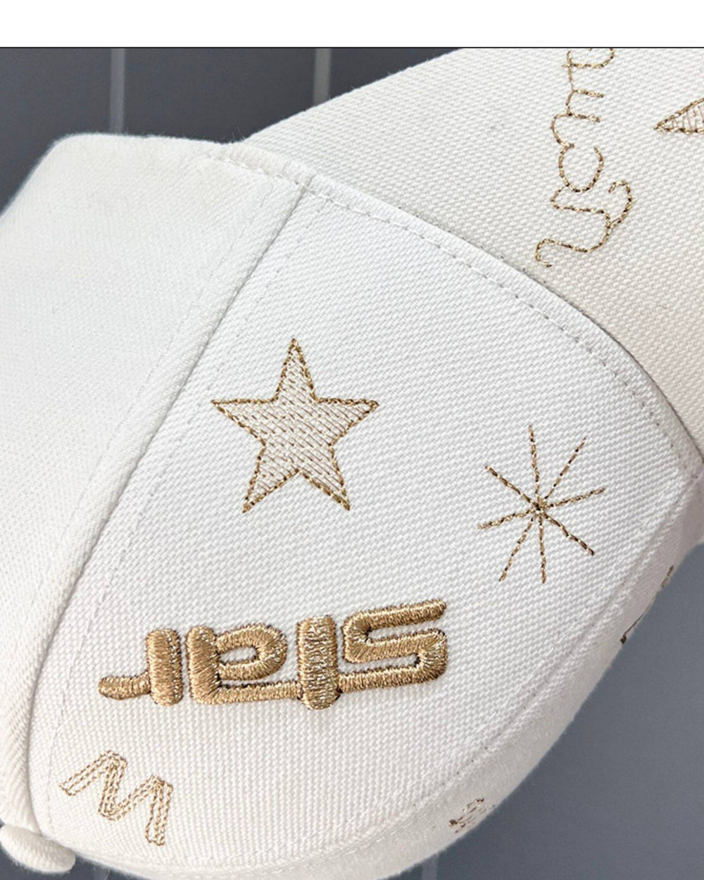Close-up of the raised star lettering and a small W embroidered on the white cap