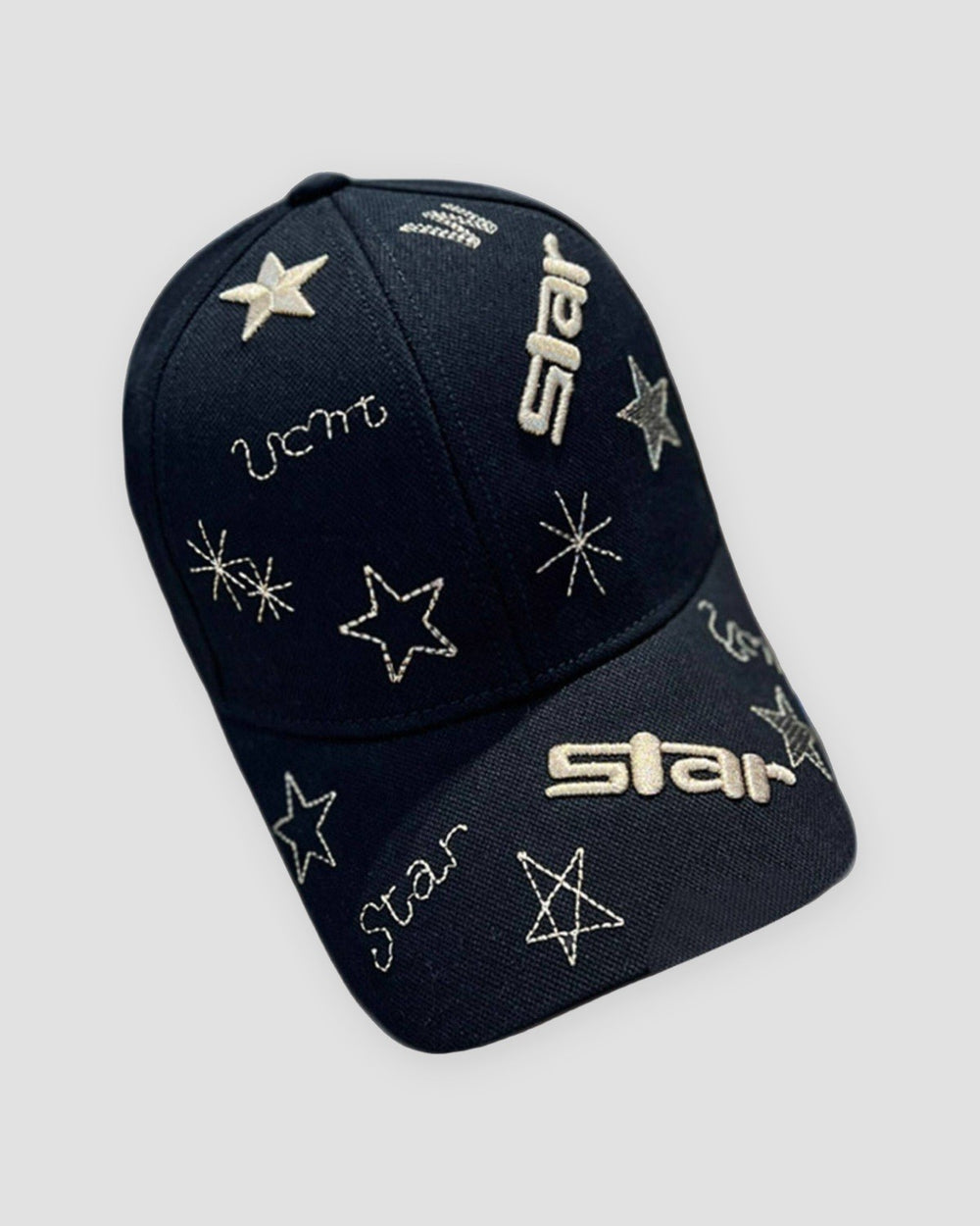 Black baseball cap with gold embroidered stars, sparks and the word star on the brim