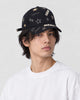 Man wearing the black baseball cap with gold embroidered stars and the word star, three-quarter view