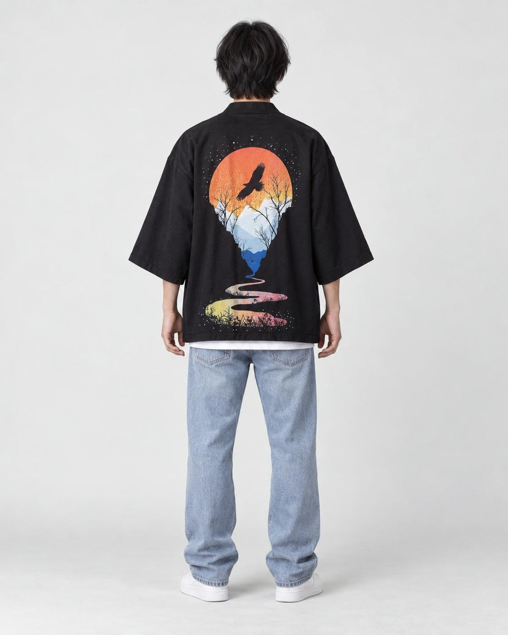 Full-length back view of a man in the black haori with an orange sun, a soaring bird and a winding river, with jeans