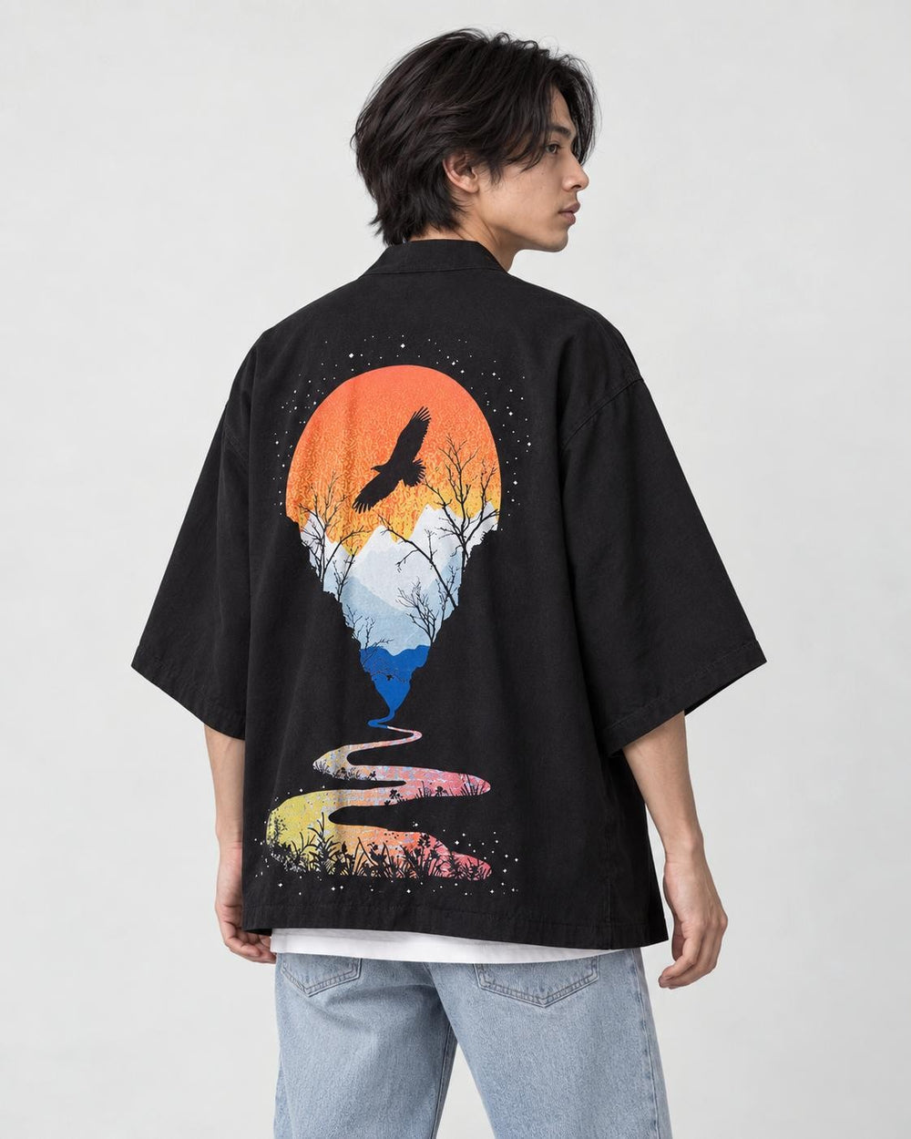 Man in the black haori seen from behind at an angle, with an orange sun and a soaring bird on the back, white tee