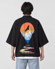 Man seen from behind in the black haori with an orange sun, a soaring bird and a winding river on the back, over a white tee