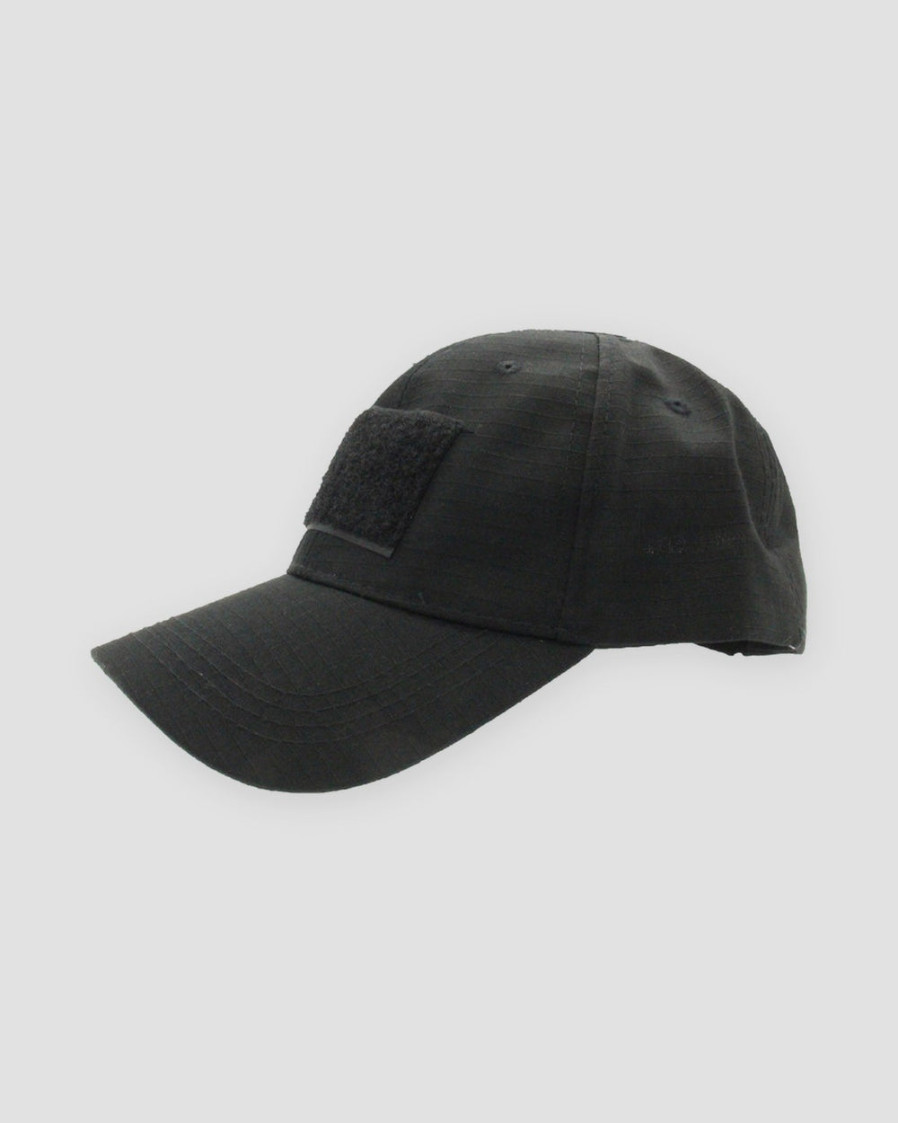 Black ripstop baseball cap from the side with a long curved brim and a front hook-and-loop panel