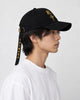 Model wearing the talisman cap, side view with the long strap hanging