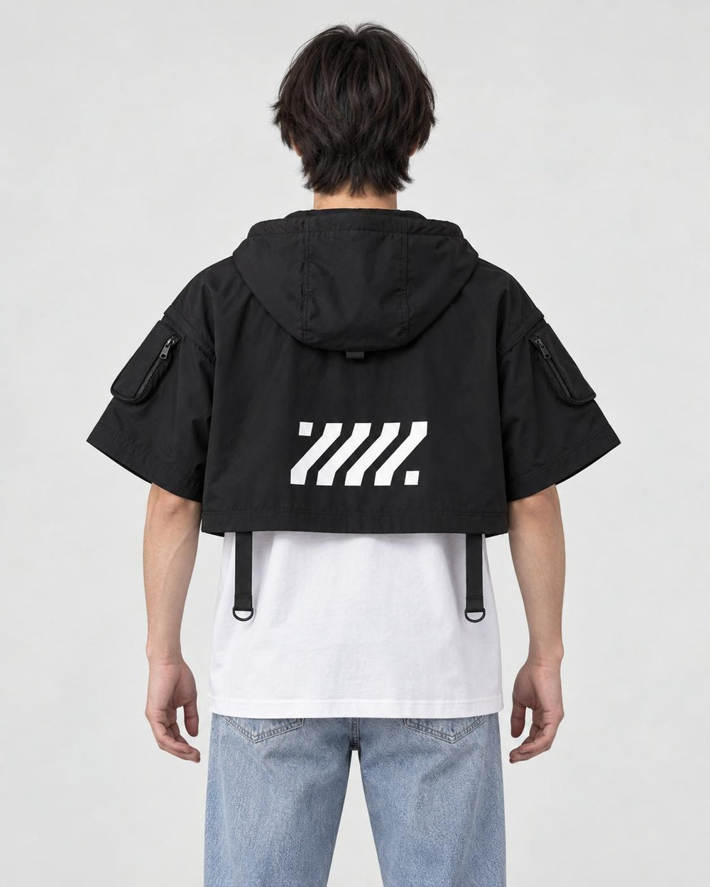 Model wearing the cropped hooded poncho top, back view of the large logo