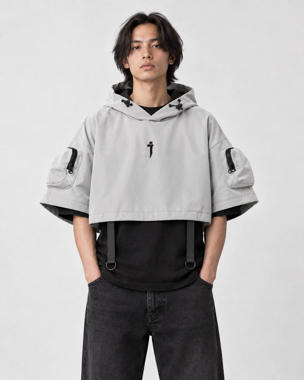 Model wearing the light gray cropped hooded poncho top over a black tee, front view